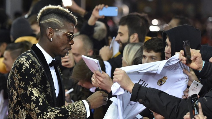 Pogba firmando una camiseta del Madrid